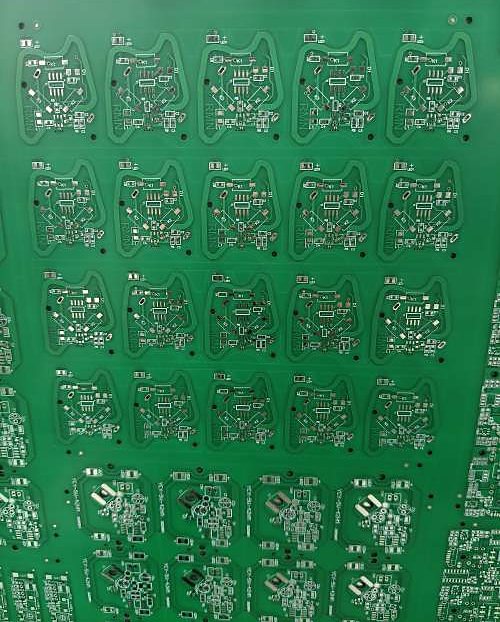 Bare green PCB panel carrying many small boards in an array